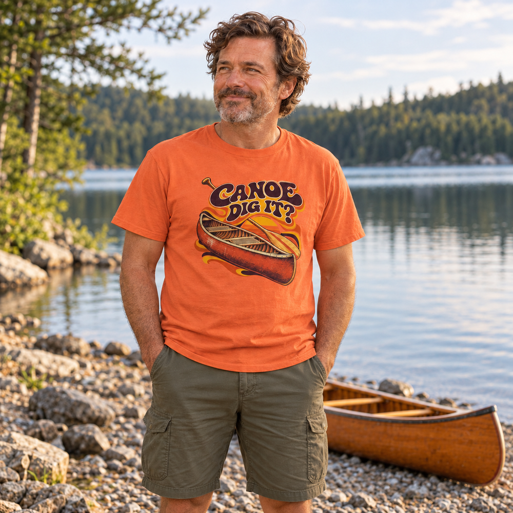Dad wearing Canoe Dig It beside a canoe resting on the shore